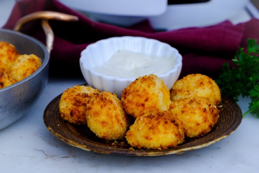 Bite size crispy potato bites with a dip on the side.