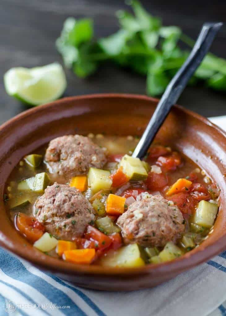 Albondigas soup with vegetables in a brown bowl