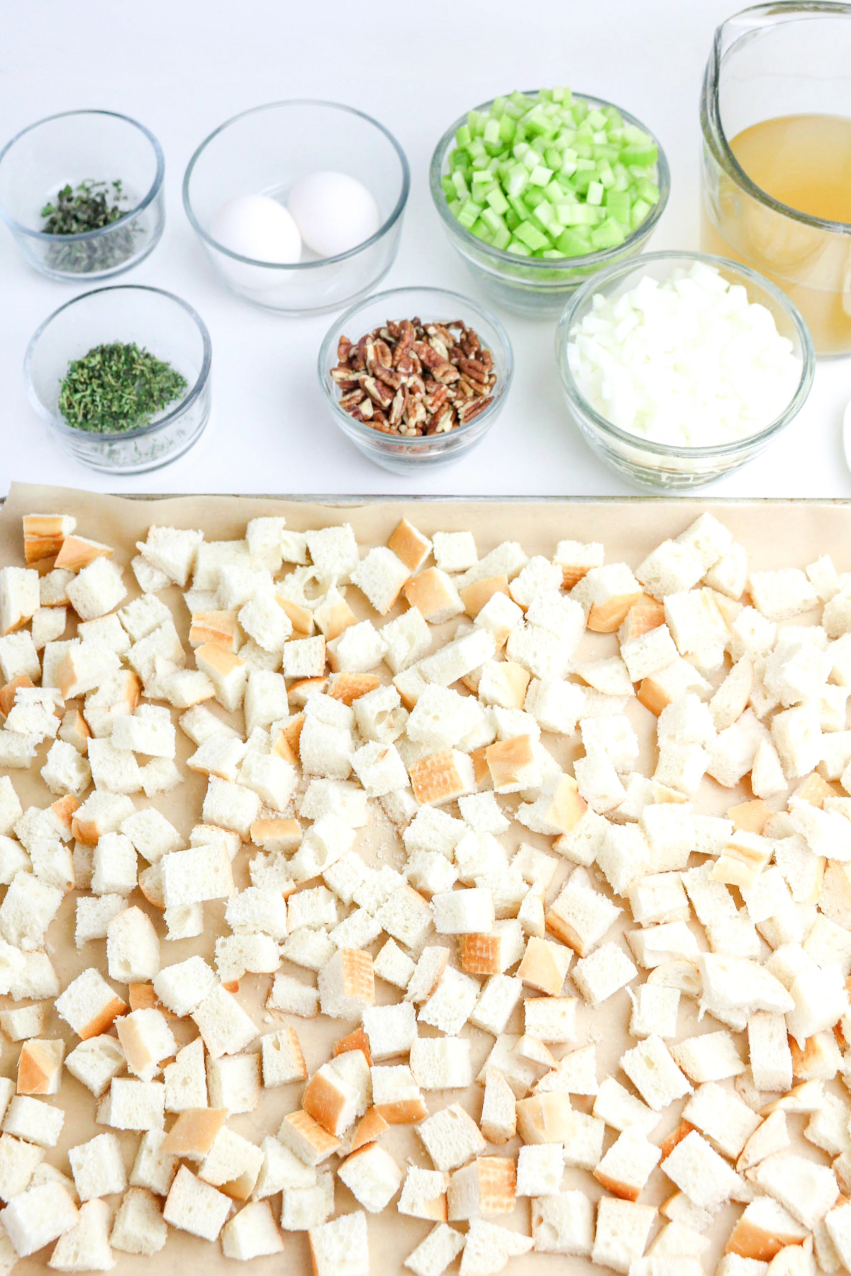 Bread cubes on a baking sheet before toasting in the oven.