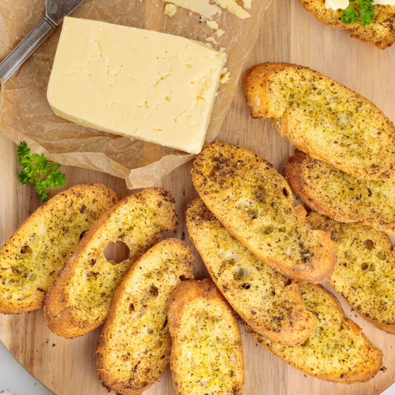 Toasted baguette crackers on a cutting board ready to eat.