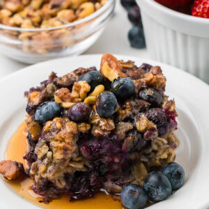 A slice of blueberry baked oatmeal with fresh berries on top.