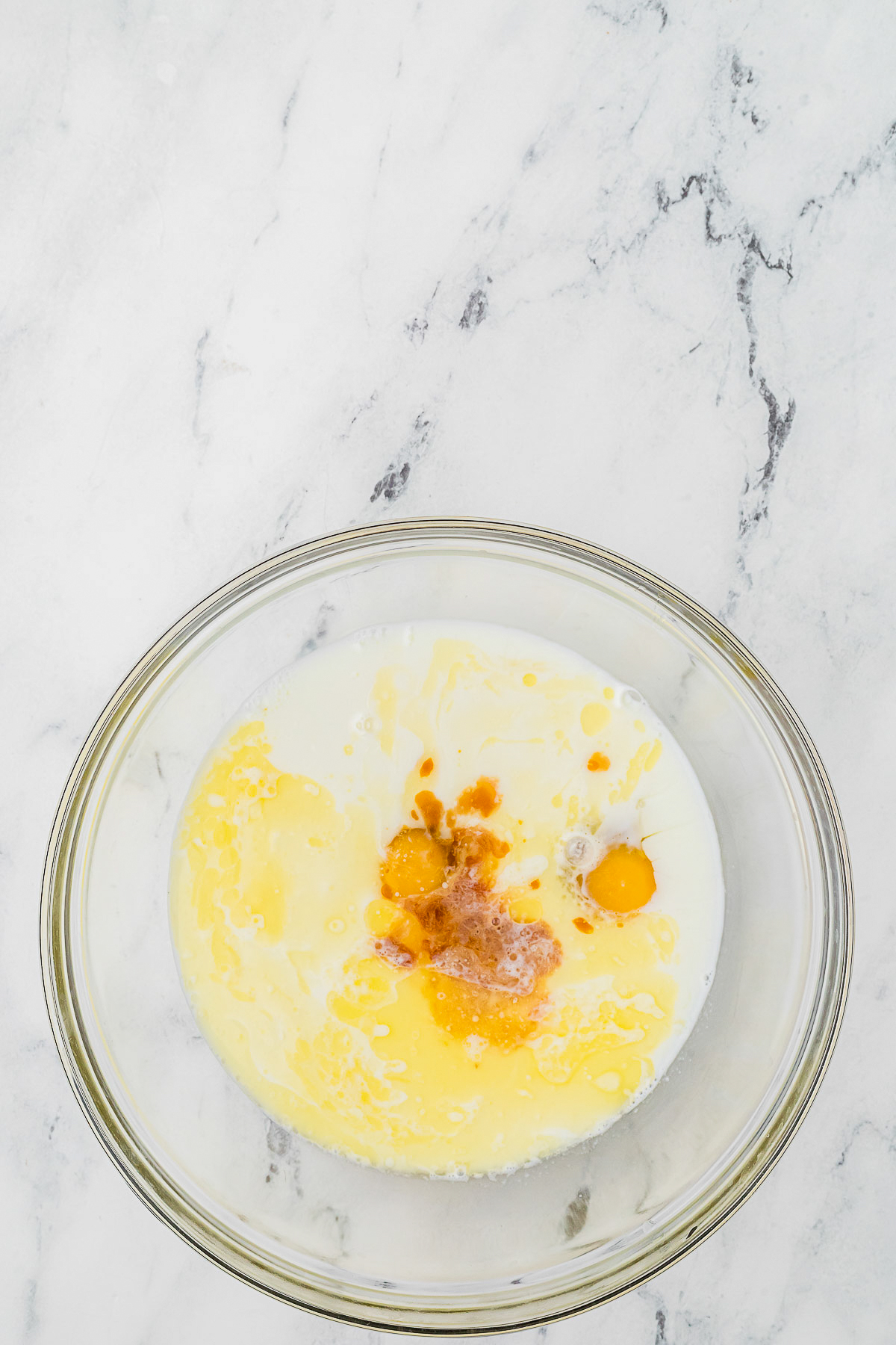 Wet ingredients in a clear mixing bowl for baked oatmeal.
