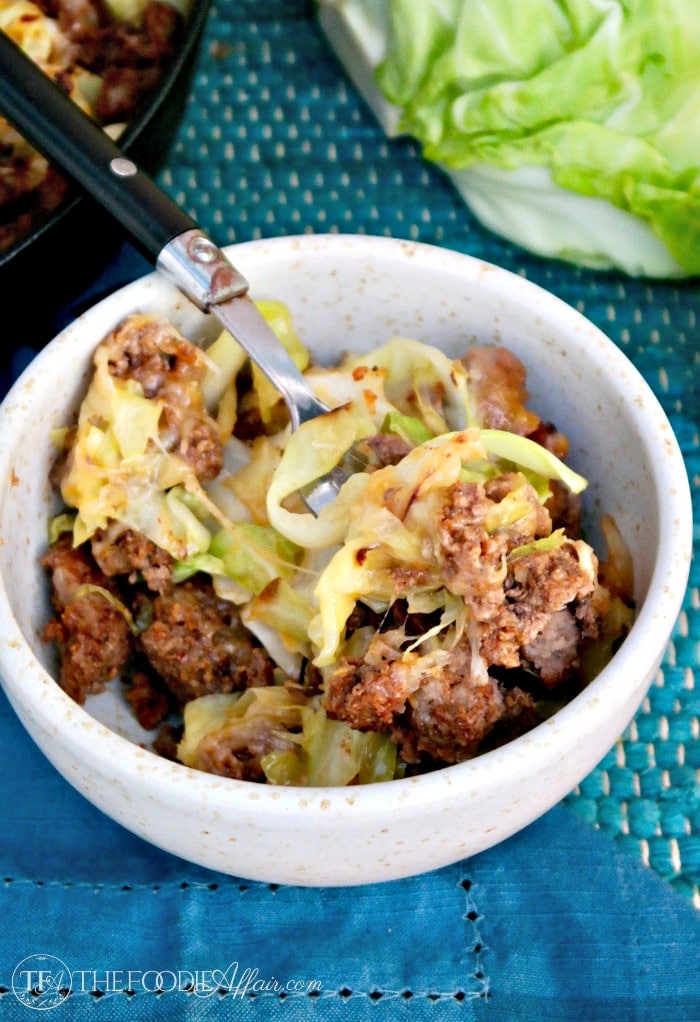 Tex Mex cabbage beef skillet in a cream bowl with blue napkin