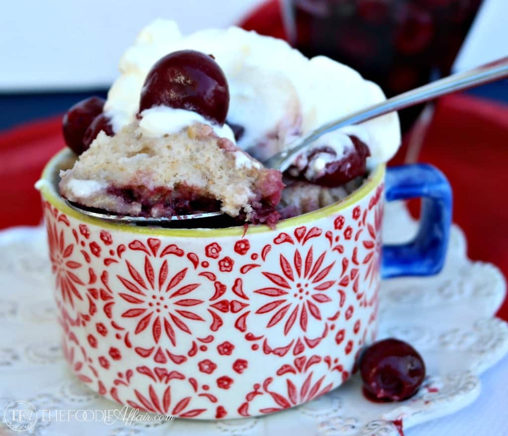 Cherry mug cake in a red cup with blue handle