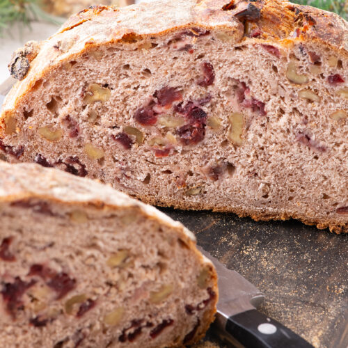 Sliced round loaf of bread with cranberries.