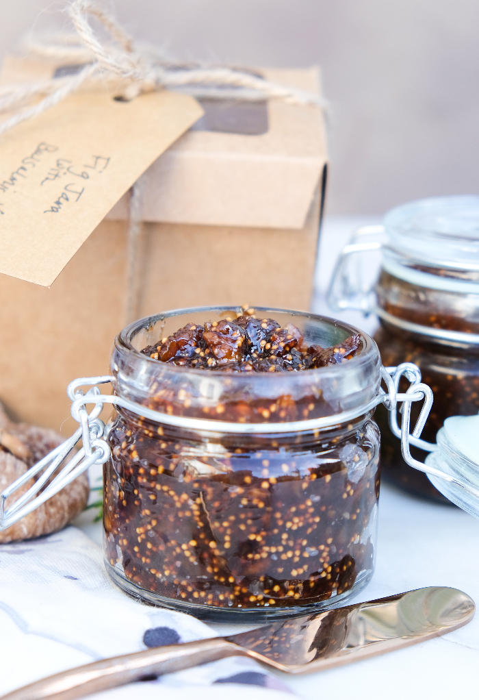 Homemade fig chutney in a clear jar with a tan box in the background.