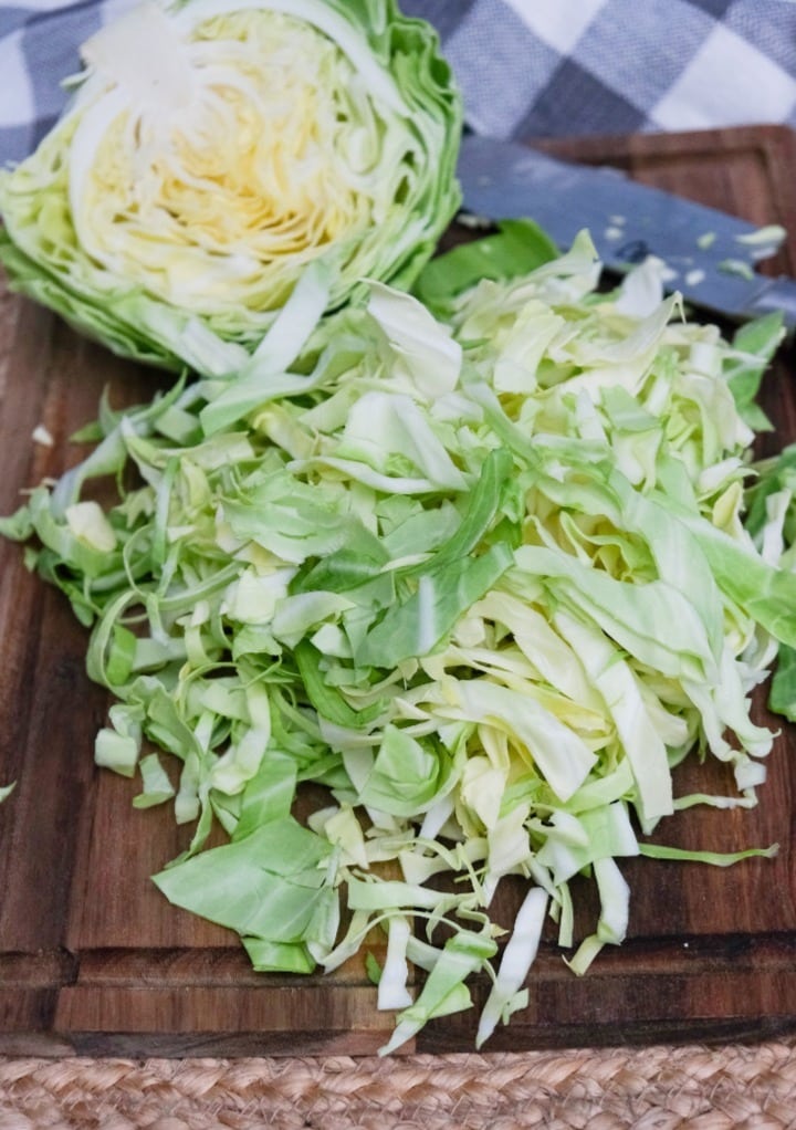 A half head of cabbage slice on a wooden cutting board.