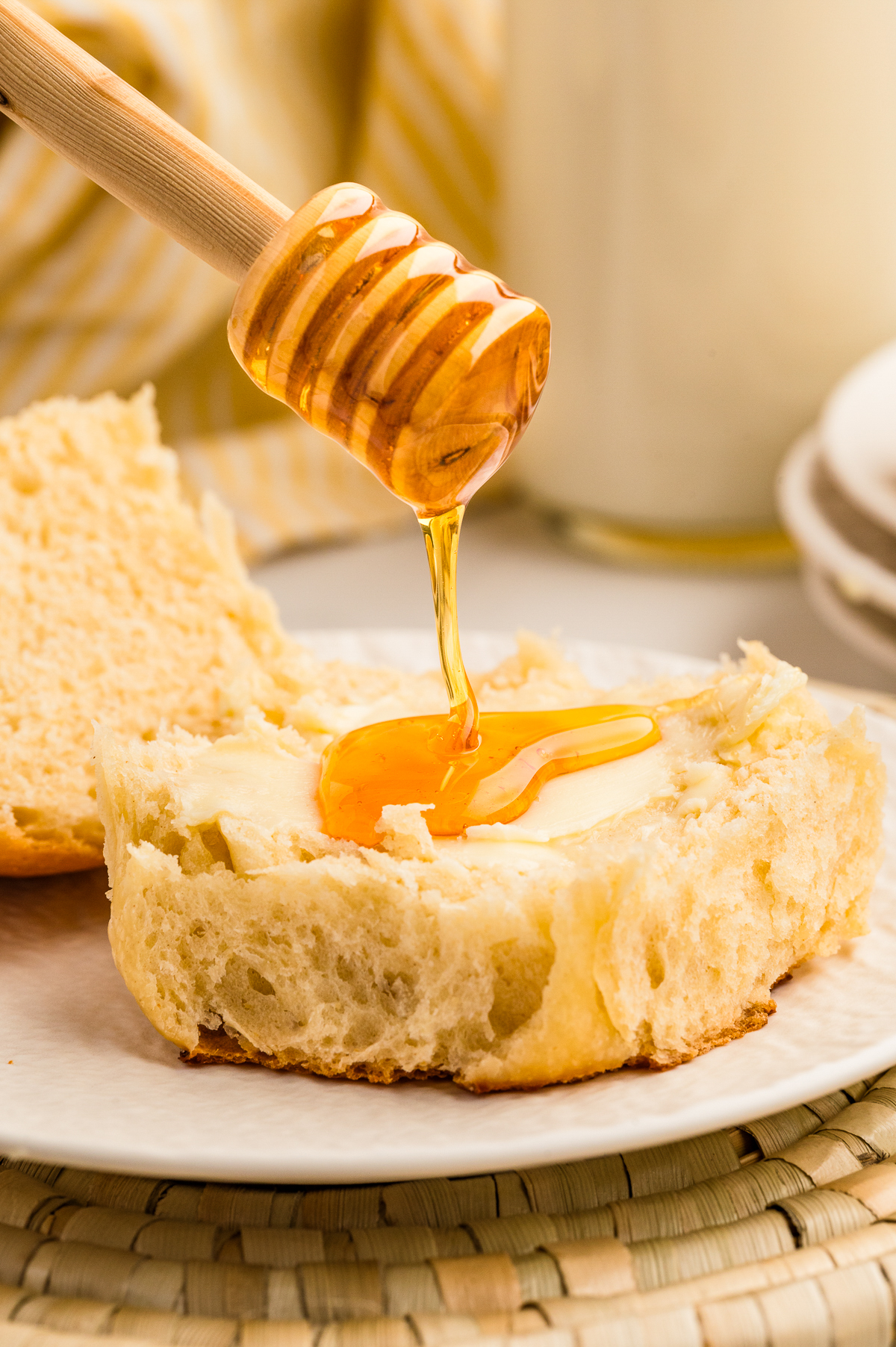 Hawaiian roll sliced in half with butter and drizzle of honey.