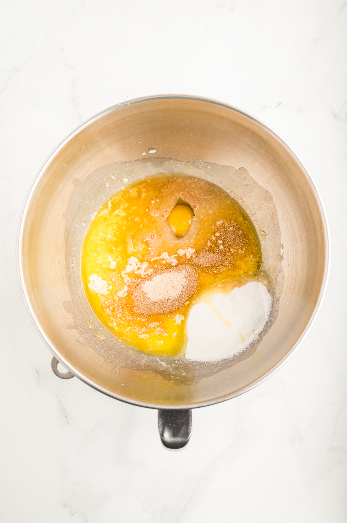 Ingredients to make hawaiian rolls in a mixer.