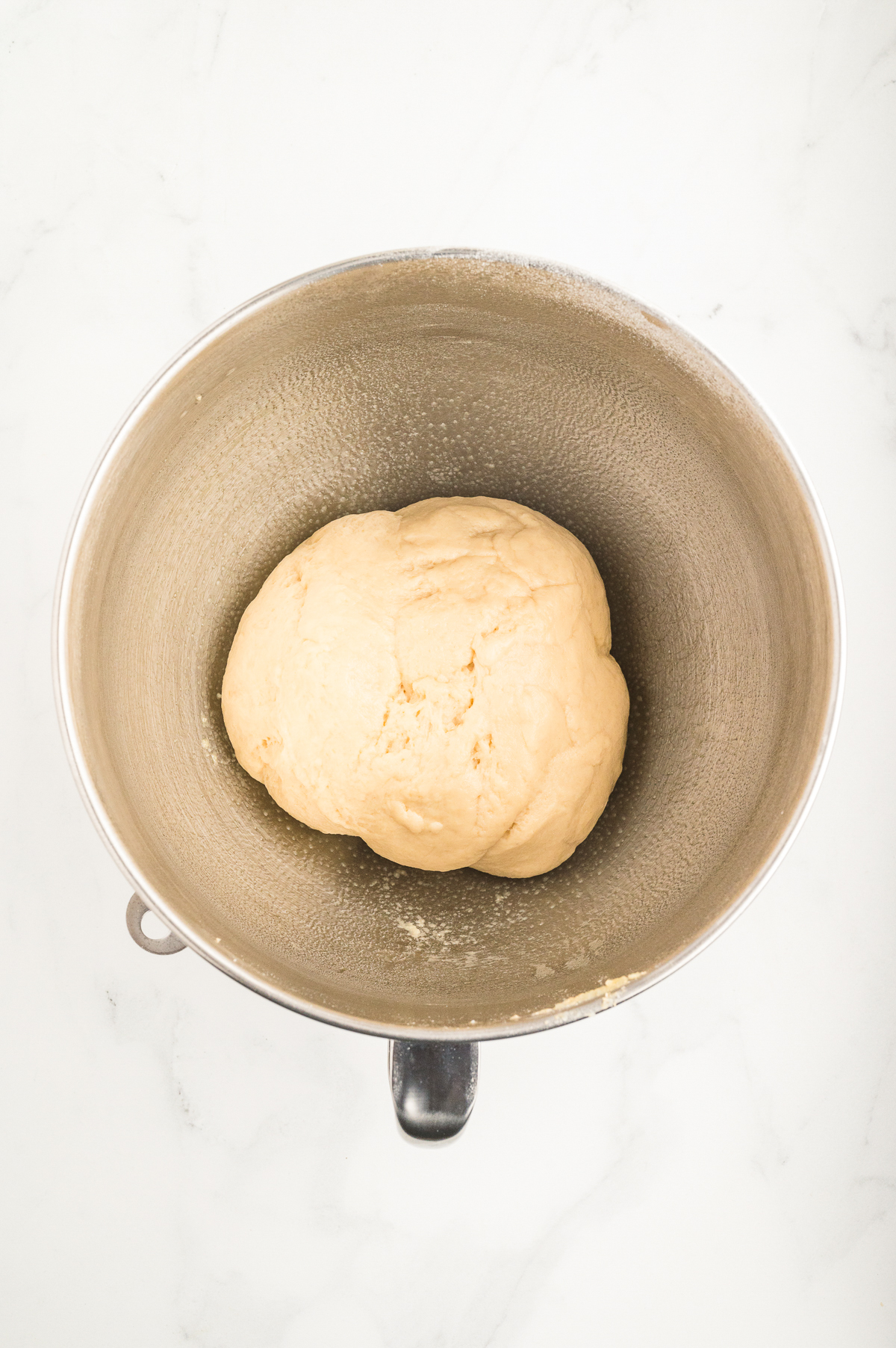 Dough before rising in a mixing bowl.
