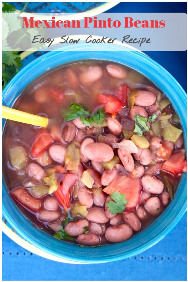 Tasty Mexican pinto beans made in a crock pot with flavorful spices like cumin, oregano, and fresh chopped tomatoes. Serve this as a main dish or a side to your favorite Latin meal! #slowcooker #crockpot #beans #Mexican