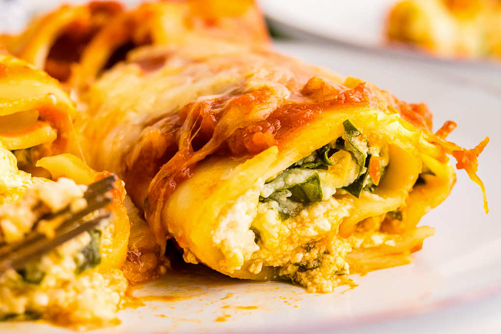 A close view of rolled manicotti with cheese and spinach.
