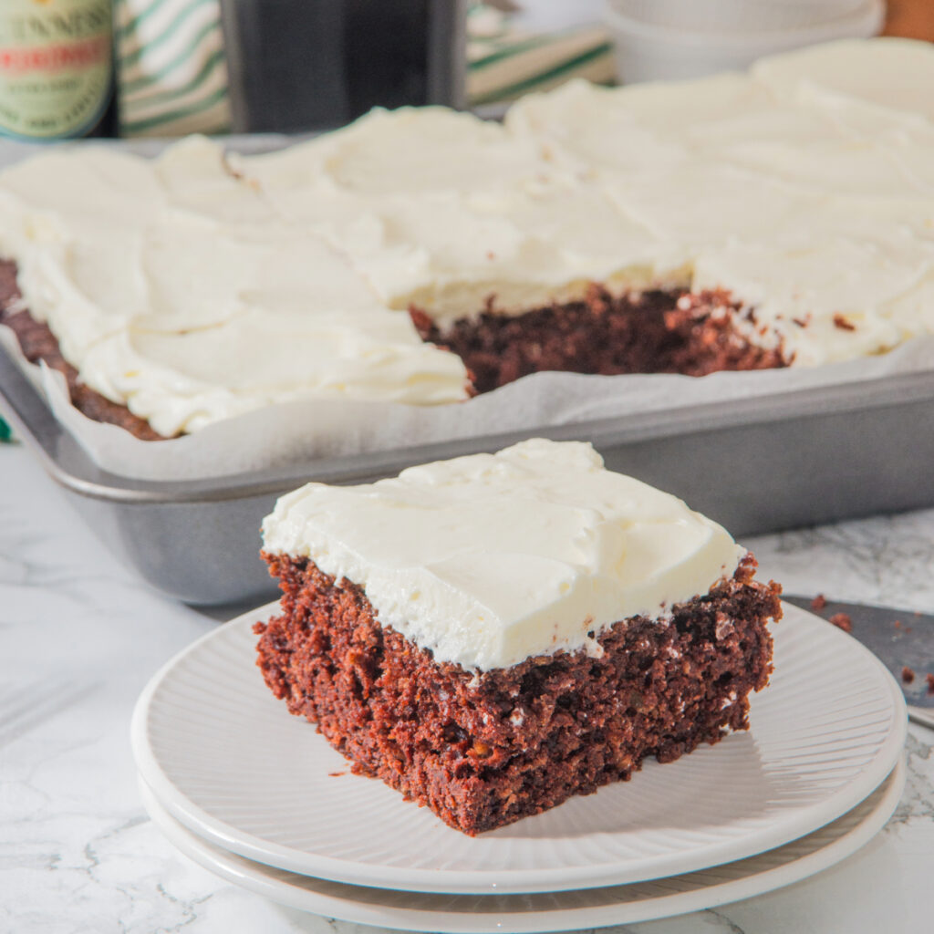 A slice of chocolate cake made with Guinness beer on a white plate ready to eat.