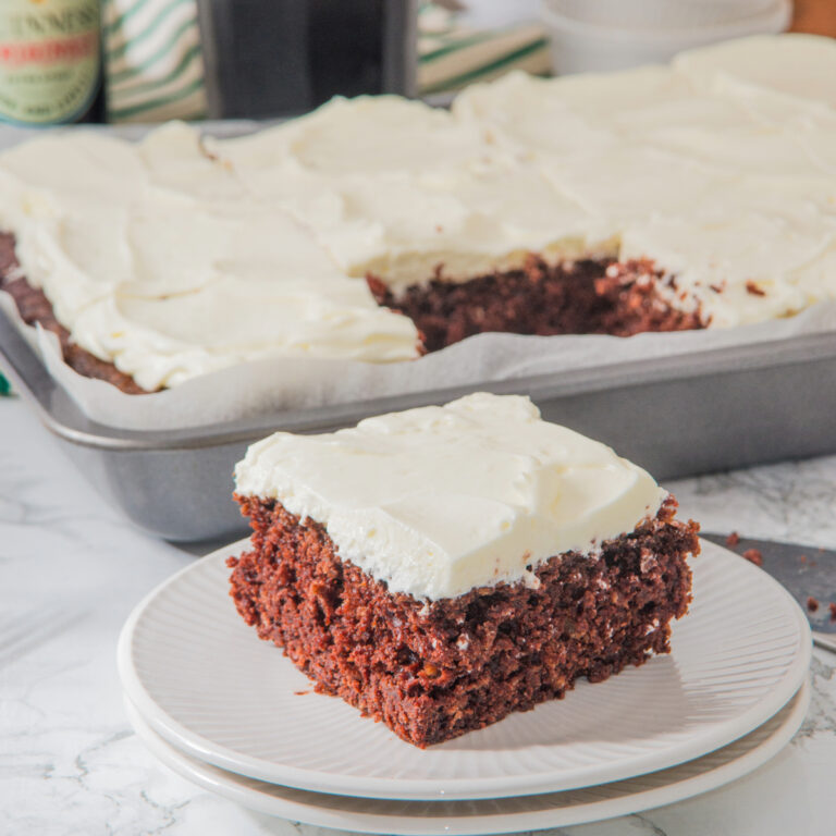 A slice of chocolate cake made with Guinness beer on a white plate ready to eat.