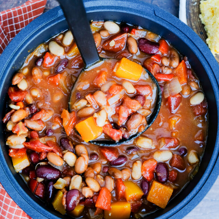 A ladle full of vegetarian chili with beans and butternut squash.